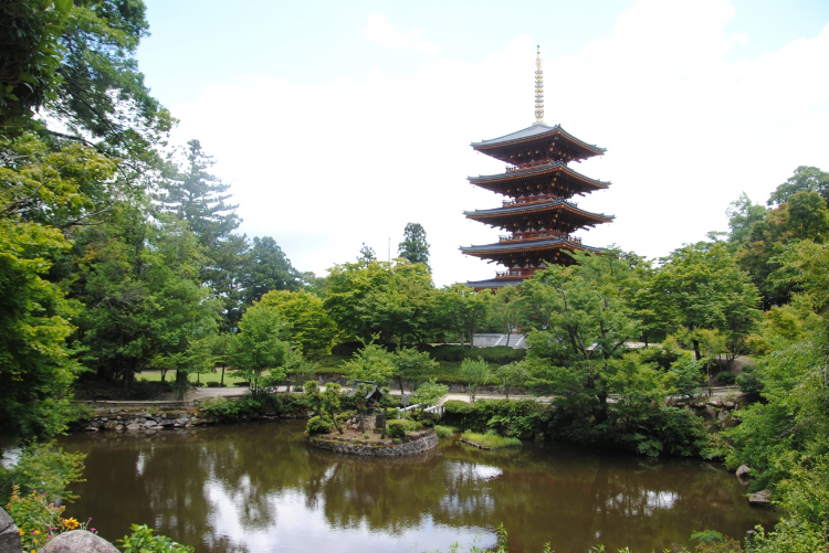 成相寺的五重塔與周圍的綠意庭園，展示日本傳統建築和自然和諧之美。